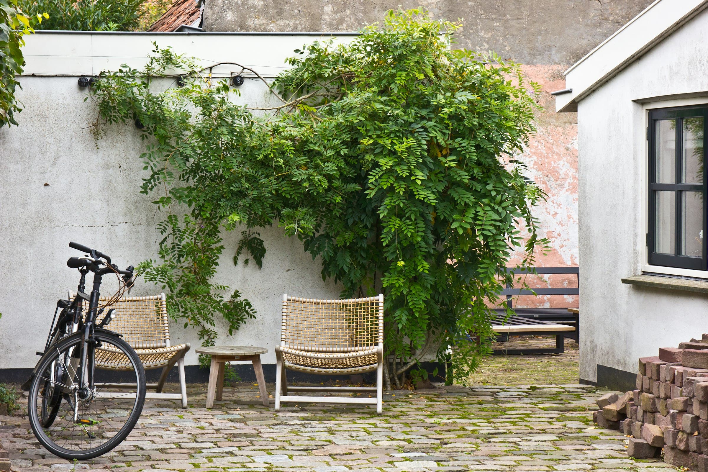 Innenhof mit Stühlen, Fahrrad und viel Grün
